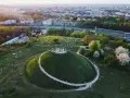 Kraków nietypowe atrakcje: Kopiec Krakusa z ludźmi na szczycie i piknikującymi na trawie. W tle rozciąga się panorama miasta.