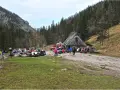 Ludzie odpoczywają przy bacówce na trasie Dolina Strążyska. W tle las i góry.