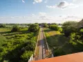 Słoneczna ścieżka rowerowa w zachodniopomorskim prowadzi przez zielone tereny nad rzeką, zachęcając do aktywnego wypoczynku.