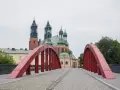 Czerwony most na Ostrowie Tumskim w Poznaniu, w tle katedra. Idealne miejsce na spacer, odkrywając poznańskie atrakcje dla dorosłych.