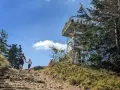 Rodzina wędruje kamienistym szlakiem na Baranią Górę. W oddali widać wieżę widokową.