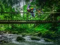 Rowerzysta wykonuje trik na drewnianym moście nad górskim potokiem. Niesamowite trasy rowerowe Zakopane czekają na odkrycie!