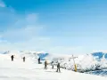 Narciarze na ośnieżonych stokach Sierra Nevada. Piękna zima w Hiszpanii, błękitne niebo i słońce.