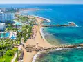 Słoneczna plaża z hotelami i basenami, turkusowe morze. Czy to Pafos czy Larnaka, wakacje marzeń!