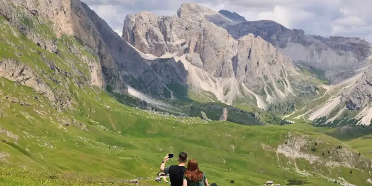 Para, która robi sobie selfie na tle Dolomitów. Idealne miejsce, gdzie warto pojechać na wakacje.