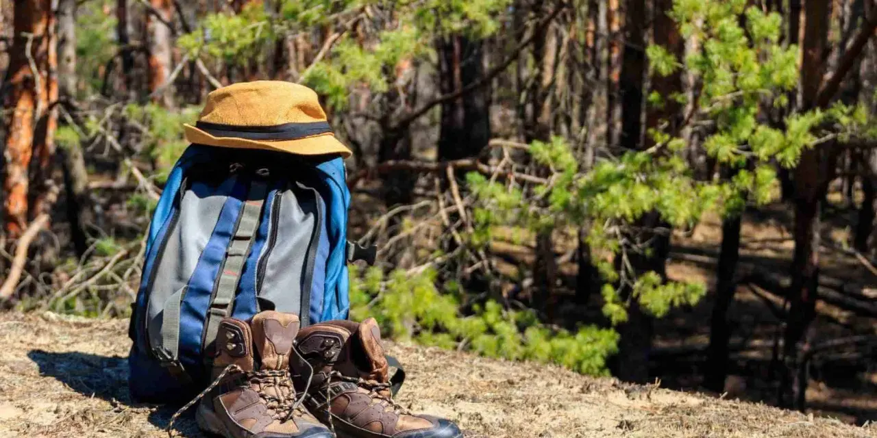 Plecak, kapelusz i buty trekkingowe gotowe na wycieczkę w góry.