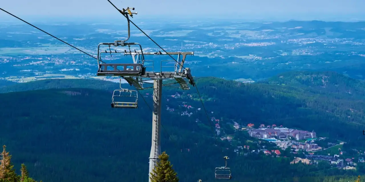 Kolejka linowa nad lasem, widok na miasteczko w dolinie. Czy to Karpacz czy Szklarska Poręba?
