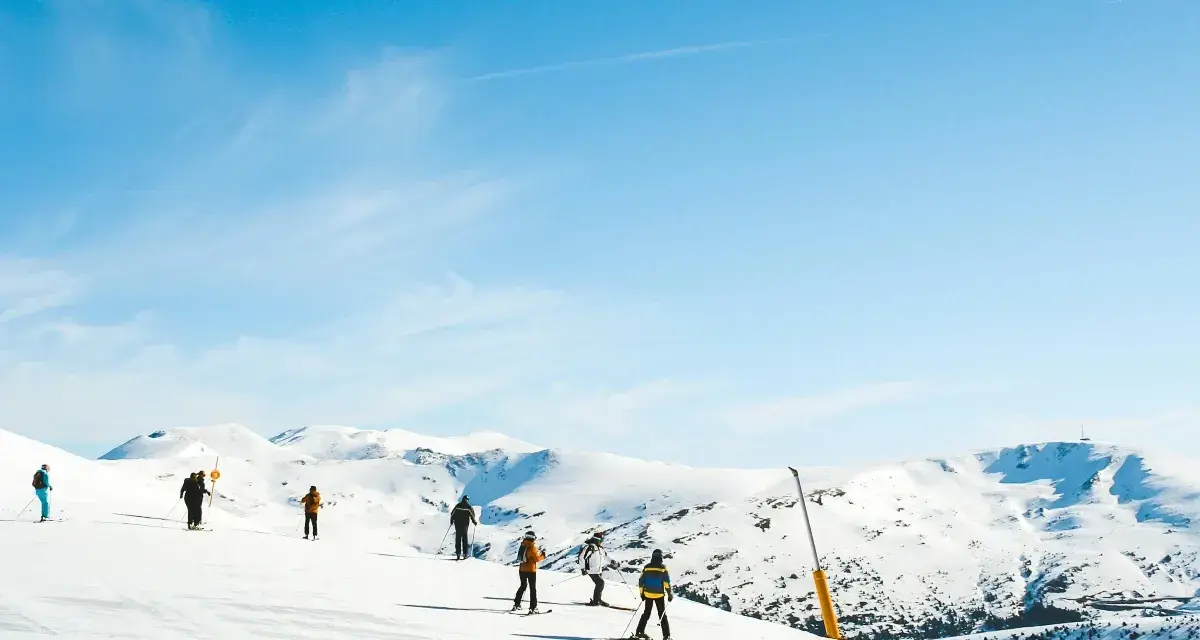 Narciarze na ośnieżonych stokach Sierra Nevada. Piękna zima w Hiszpanii, błękitne niebo i słońce.