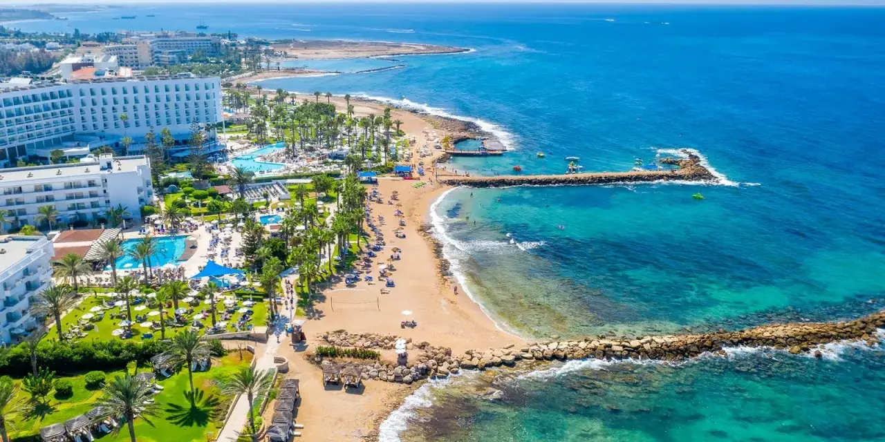 Słoneczna plaża z hotelami i basenami, turkusowe morze. Czy to Pafos czy Larnaka, wakacje marzeń!