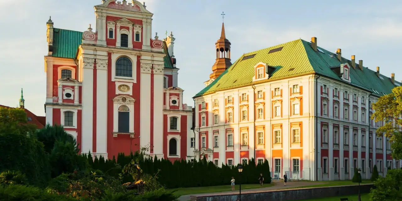 Co ciekawego w Poznaniu? Imponujące budynki dawnego kolegium jezuickiego i pałacu arcybiskupiego w złotym świetle zachodzącego słońca.
