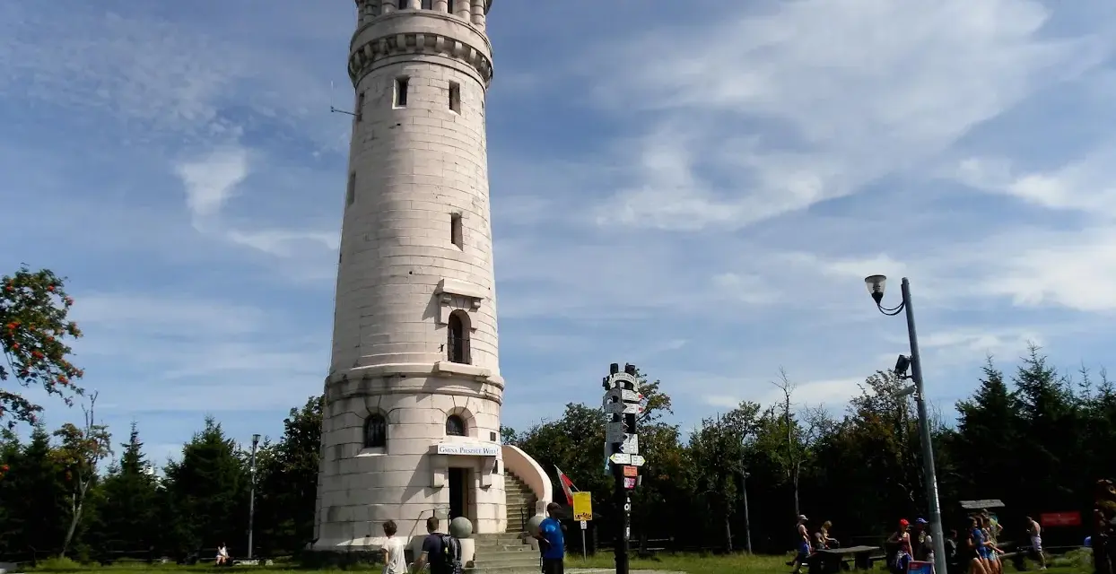 Wieża widokowa w Górach Sowich. Turyści podziwiają panoramę, szukając szlaków.