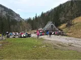 Ludzie odpoczywają przy bacówce na trasie Dolina Strążyska. W tle las i góry.