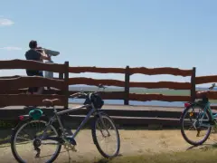 Dwa rowery czekają na odkrycie tras rowerowych Międzyzdroje. Para obserwuje widok przez lunetę.