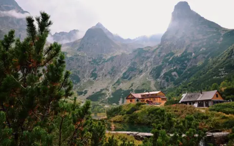 Tatry Wysokie Słowacja: schroniska nad jeziorem, otoczone zielenią i majestatycznymi szczytami gór.