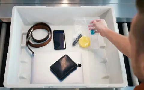 Na lotnisku wyjmujesz z bagażu podręcznego telefon, portfel, pasek i kosmetyki w przezroczystej torebce, pamiętając o **limicie płynów w bagażu podręcznym**.