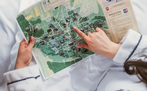 Planujesz urlop w Polsce? Ręka wskazuje na mapie atrakcje Nałęczowa, miasta z bogatą historią i uzdrowiskowymi wodami.