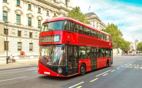 Ikoniczny czerwony autobus piętrowy na ulicy w Londynie. To świetny sposób, by dowiedzieć się, jak poruszać się po Londynie.