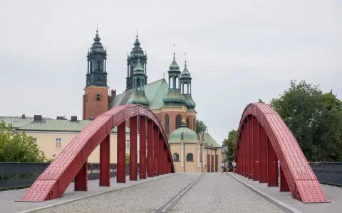 Czerwony most na Ostrowie Tumskim w Poznaniu, w tle katedra. Idealne miejsce na spacer, odkrywając poznańskie atrakcje dla dorosłych.
