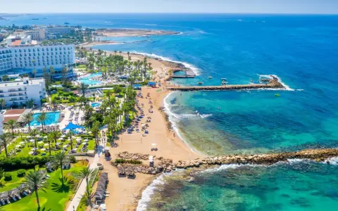 Słoneczna plaża z hotelami i basenami, turkusowe morze. Czy to Pafos czy Larnaka, wakacje marzeń!