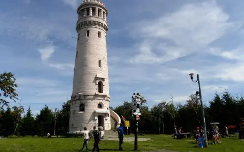 Wieża widokowa w Górach Sowich. Turyści podziwiają panoramę, szukając szlaków.