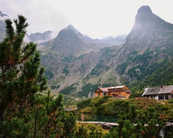 Tatry Wysokie Słowacja: schroniska nad jeziorem, otoczone zielenią i majestatycznymi szczytami gór.