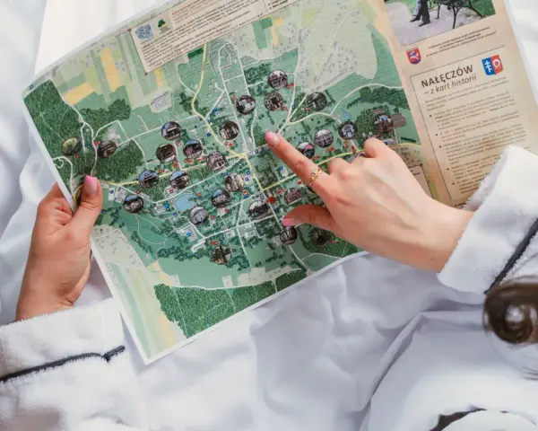 Planujesz urlop w Polsce? Ręka wskazuje na mapie atrakcje Nałęczowa, miasta z bogatą historią i uzdrowiskowymi wodami.