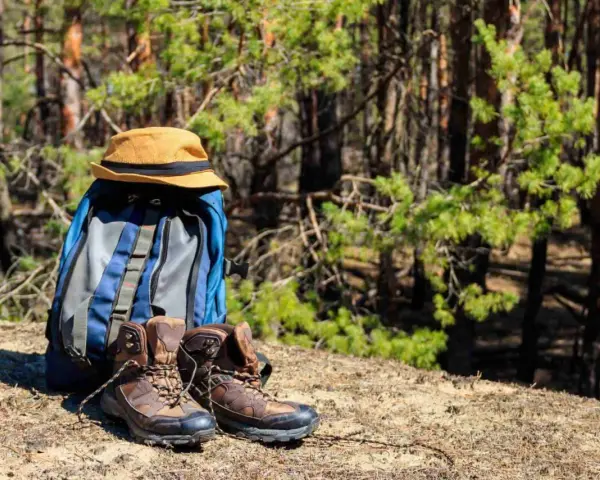 Plecak, kapelusz i buty trekkingowe gotowe na wycieczkę w góry.