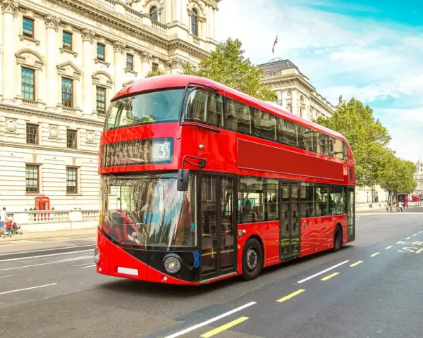 Ikoniczny czerwony autobus piętrowy na ulicy w Londynie. To świetny sposób, by dowiedzieć się, jak poruszać się po Londynie.