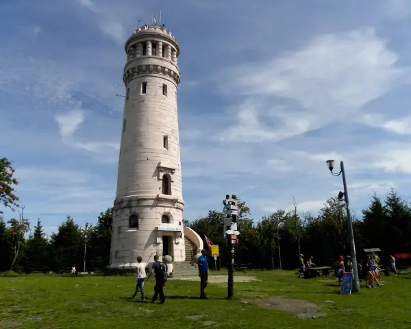 Wieża widokowa w Górach Sowich. Turyści podziwiają panoramę, szukając szlaków.