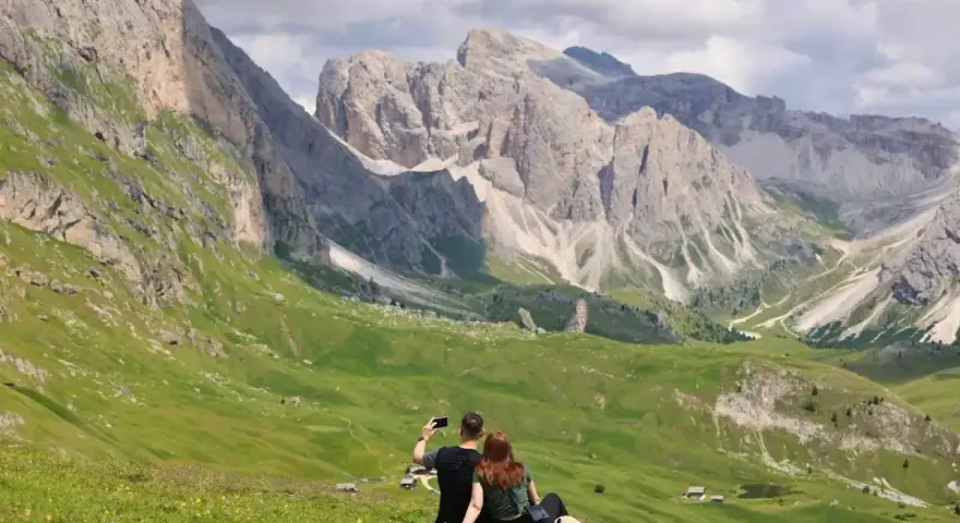 Para, która robi sobie selfie na tle Dolomitów. Idealne miejsce, gdzie warto pojechać na wakacje.