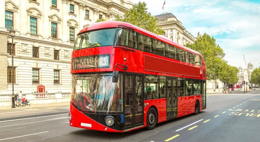 Ikoniczny czerwony autobus piętrowy na ulicy w Londynie. To świetny sposób, by dowiedzieć się, jak poruszać się po Londynie.