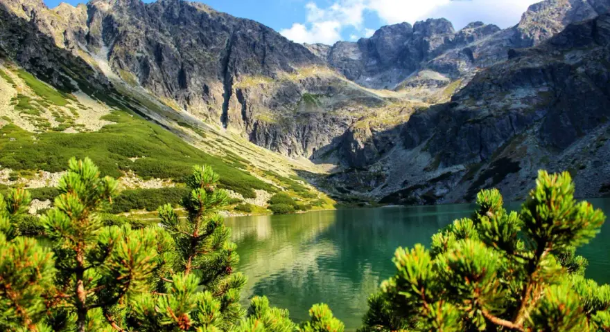 Malowniczy czarny staw gąsienicowy trasa w otoczeniu skalistych gór i zielonych zboczy.