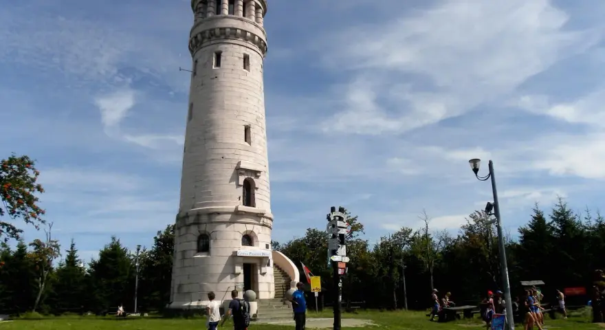 Wieża widokowa w Górach Sowich. Turyści podziwiają panoramę, szukając szlaków.