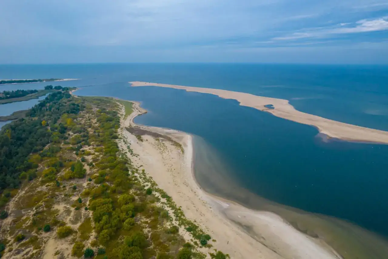 Piękny krajobraz nad morzem, idealne miejsce na urlop w Polsce. Piaszczysta plaża, zieleń i błękit wody.