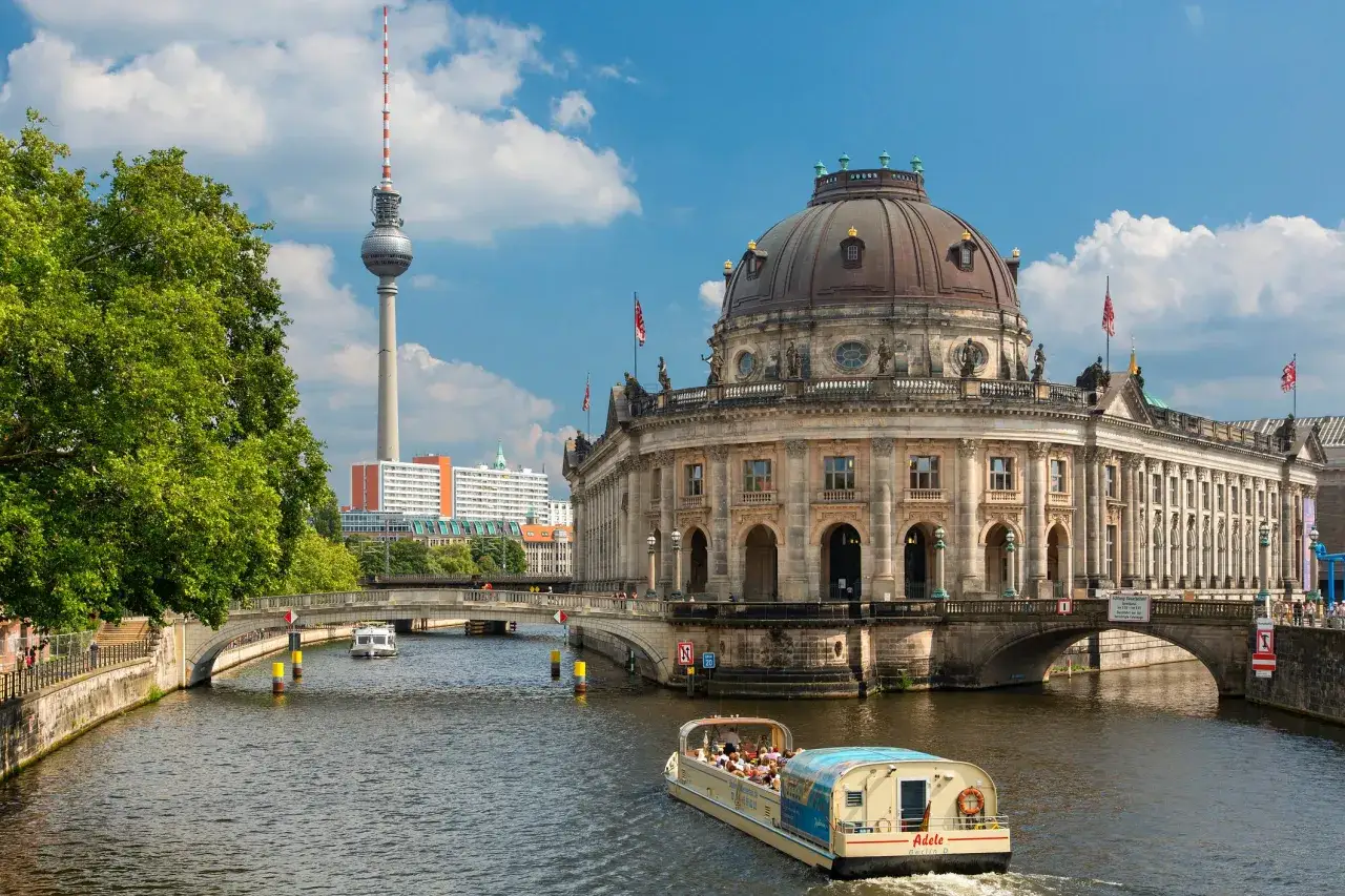 Widok na Sprewę z łodzią wycieczkową, w tle Bode Museum i wieża telewizyjna. Piękne zabytki w Berlinie.