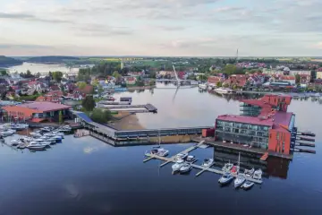 Widok na mazurskie miasteczko z nowoczesną mariną i hotelami. Idealne miejsce, by odkryć, co warto zobaczyć na Mazurach.